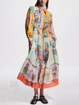front view of a woman in a long, flowing, multi-colored dress with an abstract print and a collared neckline