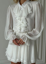 close-up of woman's torso in white dress