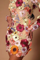 Detail of a beige sheer dress with 3D floral embellishments, showing the texture and vibrant colors.
