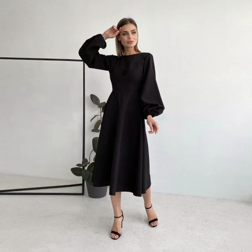 woman wearing a black midi dress with bishop sleeves and high heels
