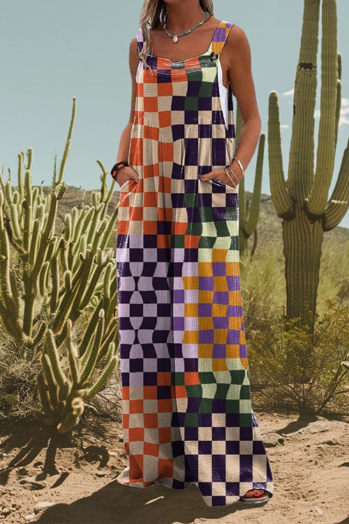 Woman wearing a colorful checkered jumpsuit, standing in a desert landscape with cacti.