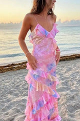 Woman wearing a pink and blue tie-dye maxi dress with ruffles on the beach
