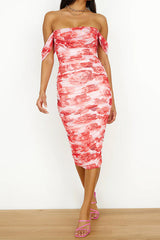 woman in a pink and red floral print off-the-shoulder ruched midi dress and pink strappy heels