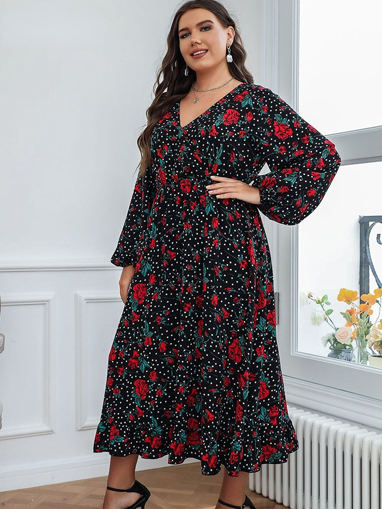 A plus-size woman wearing a black floral and polka dot midi dress with long bishop sleeves and a v-neck.