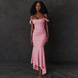 A Black woman models a pink off-the-shoulder ruched mermaid gown with a high-low hemline.