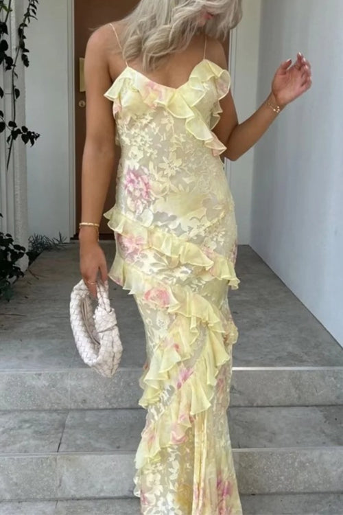 Woman wearing a yellow floral print maxi dress with ruffles on stairs