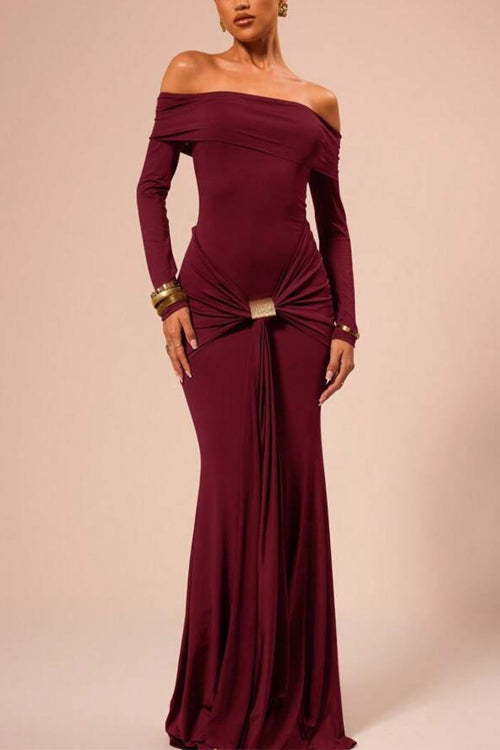 Woman wearing a long, off-the-shoulder maroon dress with ruched detailing and a gold buckle at the waist.