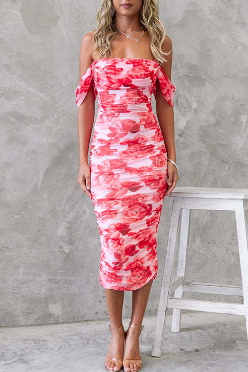 Front view of a woman in a pink and red floral print ruched midi dress