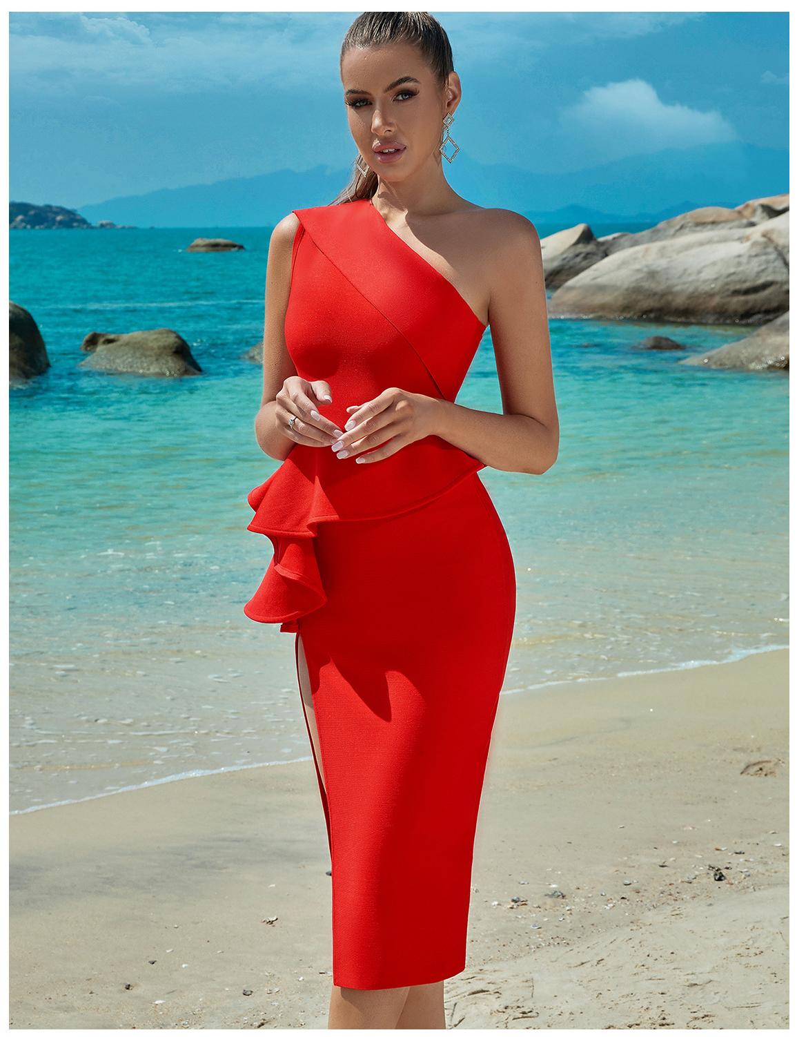 woman in red one-shoulder dress with peplum and high slit posing on the beach