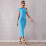 Woman walking forward in a vibrant blue one-shoulder midi dress and nude heels.