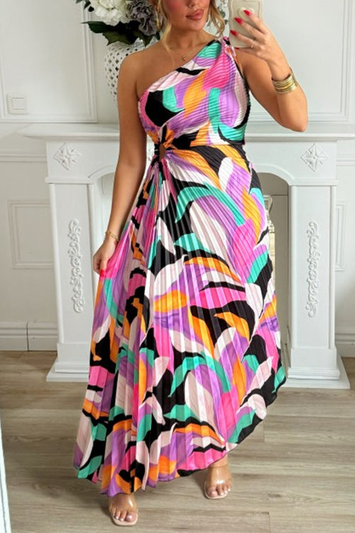 woman in a colorful one-shoulder pleated maxi dress with an abstract print