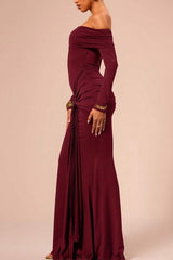 Side view of a woman in a long, off-the-shoulder maroon dress with ruched detailing and a gold buckle.