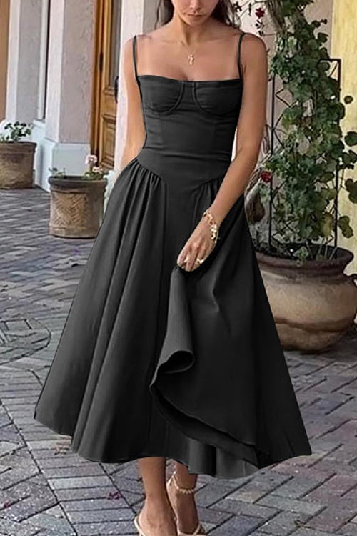 Woman wearing a black bustier midi dress with a full pleated skirt and strappy heels.
