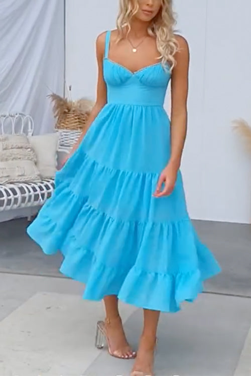 Woman in a blue tiered midi dress from the front