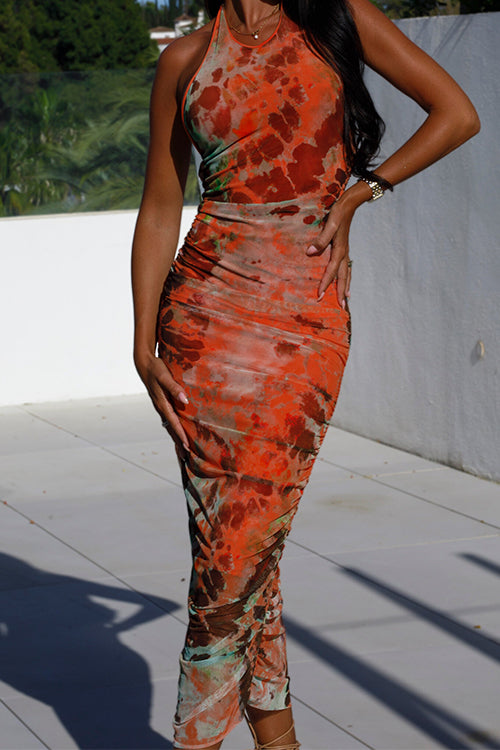 Close-up of a woman modeling an orange and brown tie-dye print ruched halter neck midi dress, focusing on the fabric and ruching.