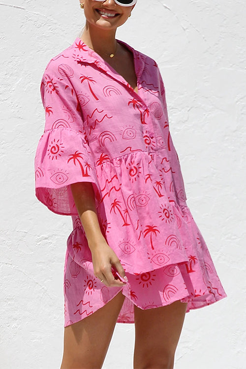 A woman modeling a pink short dress with a playful print.