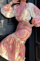 Close-up of a woman's torso in a pink and white paisley print set, showing the details of the blouse and skirt.