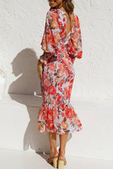 woman wearing a red and orange floral print dress with a smocked bodice and ruffled hem