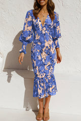 woman wearing a blue floral print dress with balloon sleeves and a ruffled hem