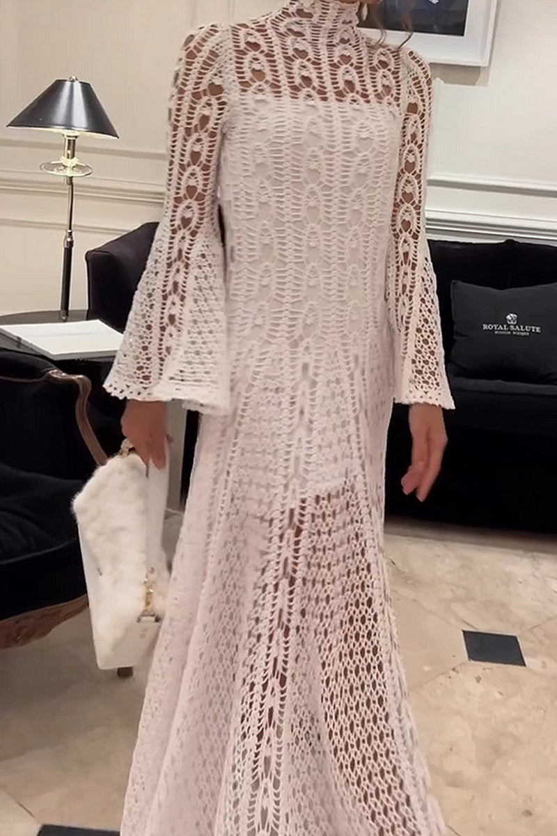 Woman standing in a white crochet dress holding a white furry clutch