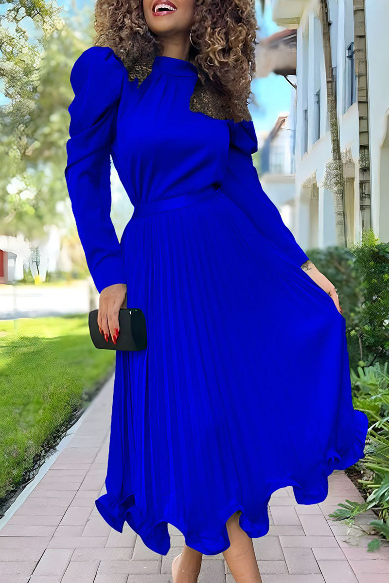 woman in a royal blue pleated dress with puffy sleeves