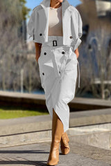 Woman wearing a white cropped jacket and matching asymmetrical skirt with tan boots
