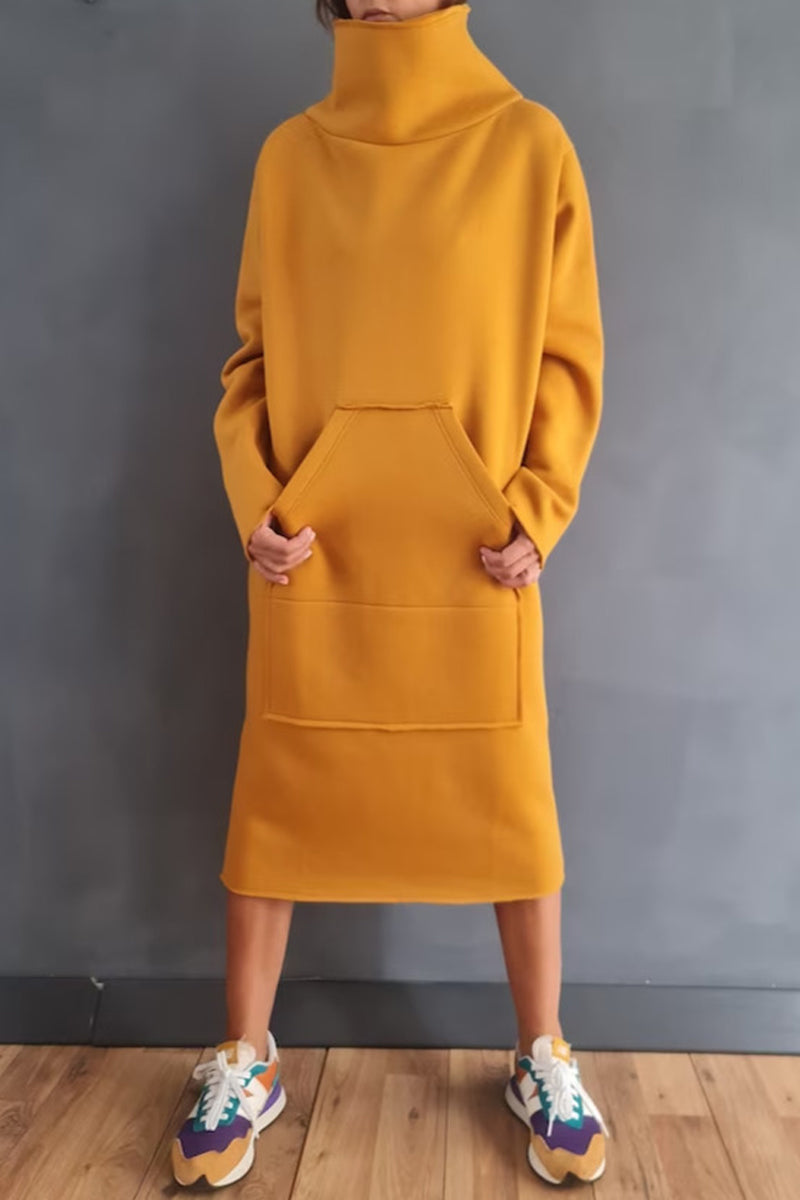 Woman wearing a yellow hooded dress with pockets and colorful sneakers.