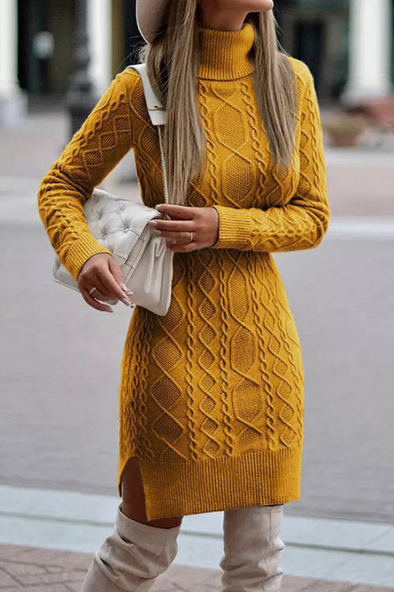 A woman wearing a yellow cable knit turtleneck sweater dress with a white handbag.