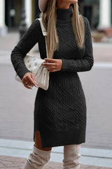 A woman wearing a black cable knit turtleneck sweater dress with a white handbag.