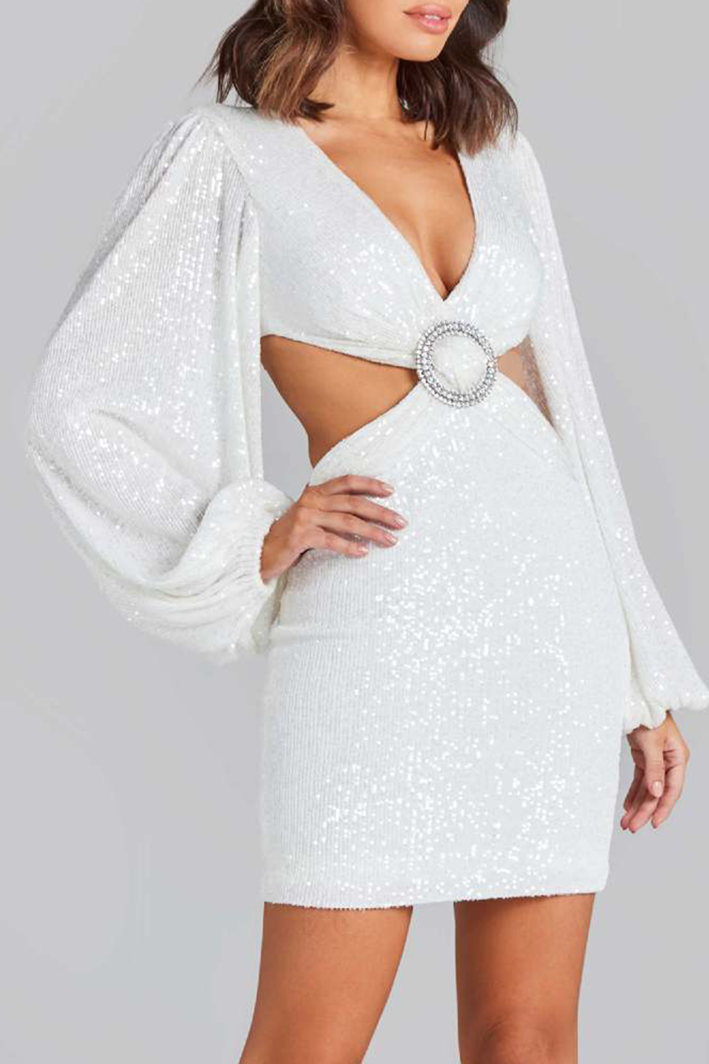 side view of a woman in a white sequined mini dress with a plunging neckline and cut-outs