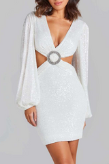 woman wearing a white sequined mini dress with long balloon sleeves and a plunging neckline