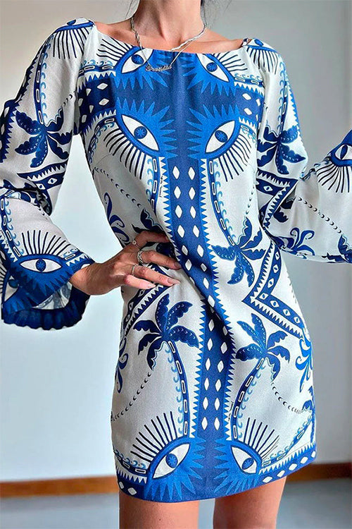 Woman wearing a white and blue printed mini dress with bell sleeves