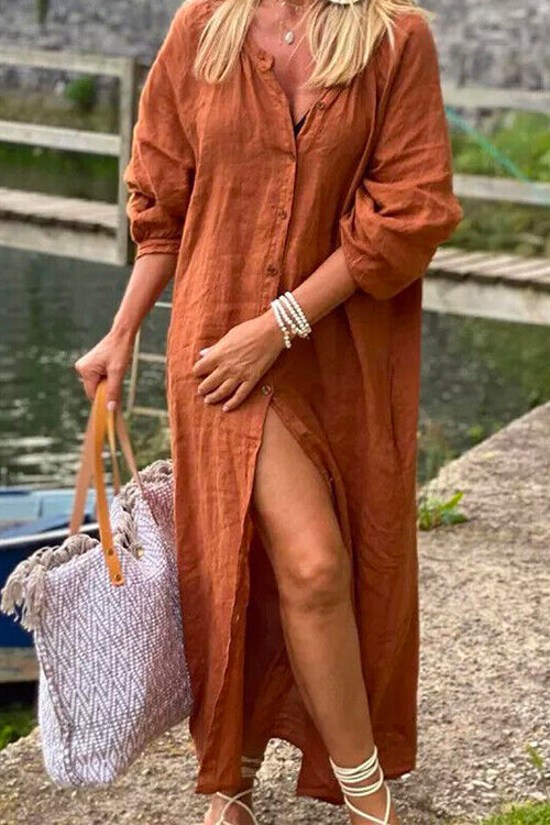 woman wearing a rust-colored long button-down dress with a high slit and a tote bag