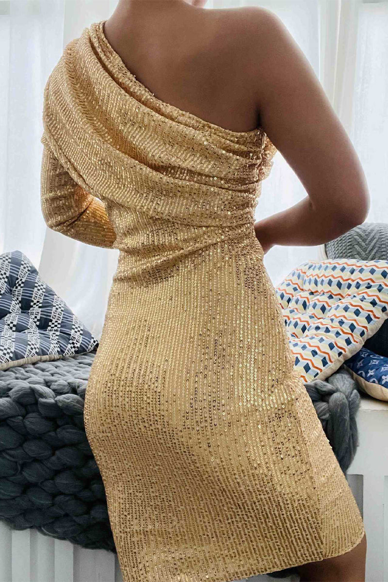 Back view of a woman in a gold sequined one-shoulder dress.