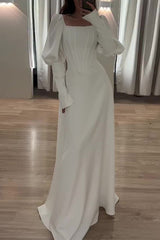 A woman in a white long-sleeved dress with a square neckline and a corset bodice.