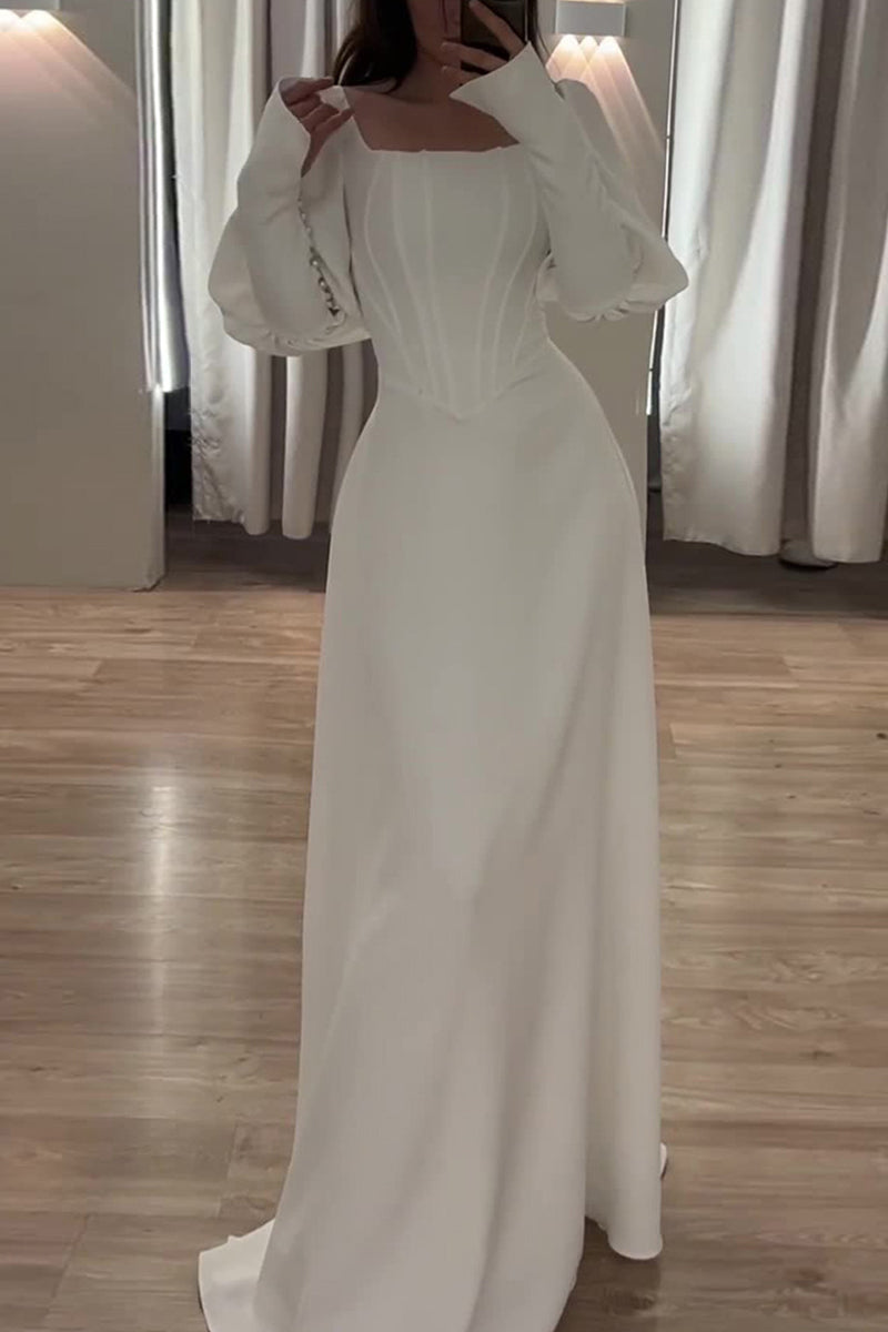 A woman models a white A-line dress with puff sleeves and a corset bodice.