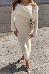 A woman wearing a white off-the-shoulder knit midi dress with long sleeves, and beige pointed-toe heels.