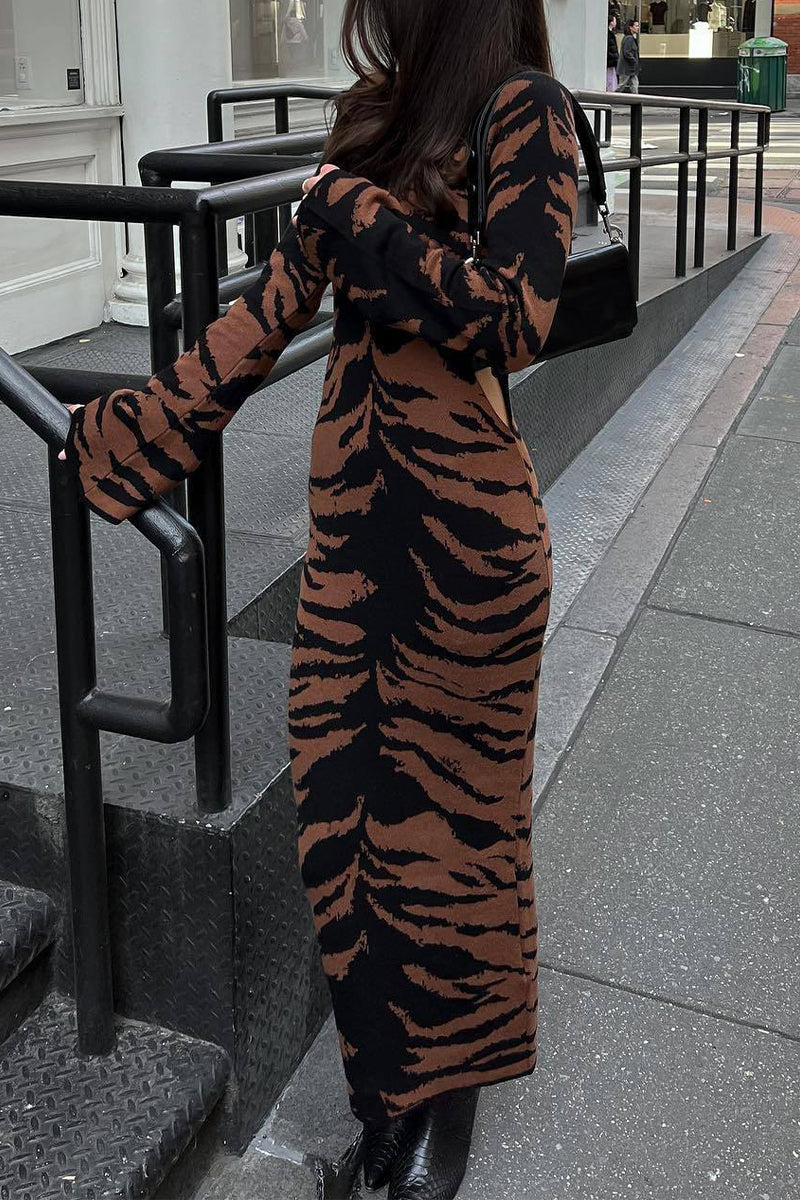 Woman in a tiger-print midi dress standing on stairs.