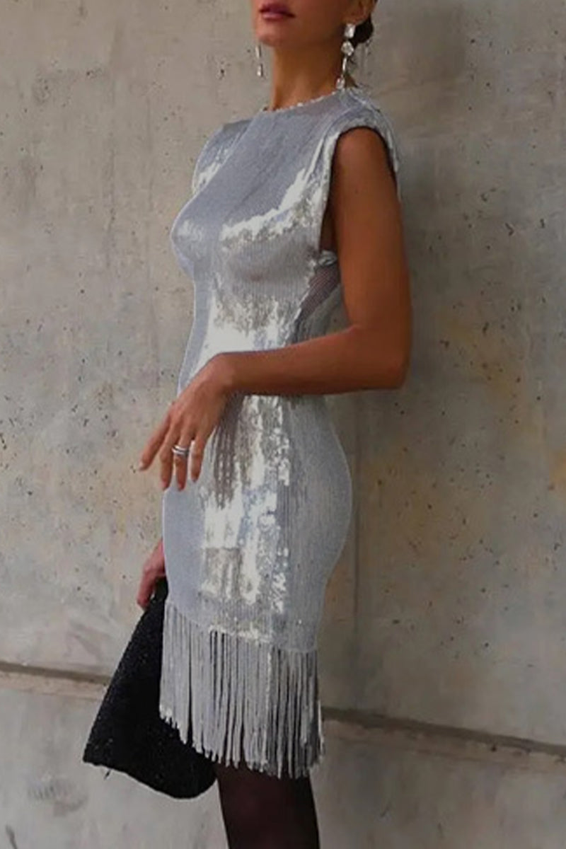 Side view of a woman wearing a silver sequined dress with a fringe hem.
