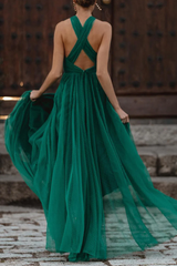 A woman twirling in a green polka dot halter dress, showcasing the flowing skirt.