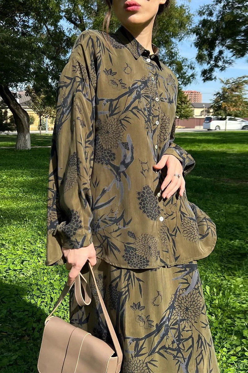 Close-up of the woman's outfit, showing the detail of the floral print on the shirt and skirt.