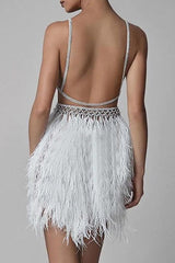 Back view of a woman in a white mini dress with a feather skirt and open back