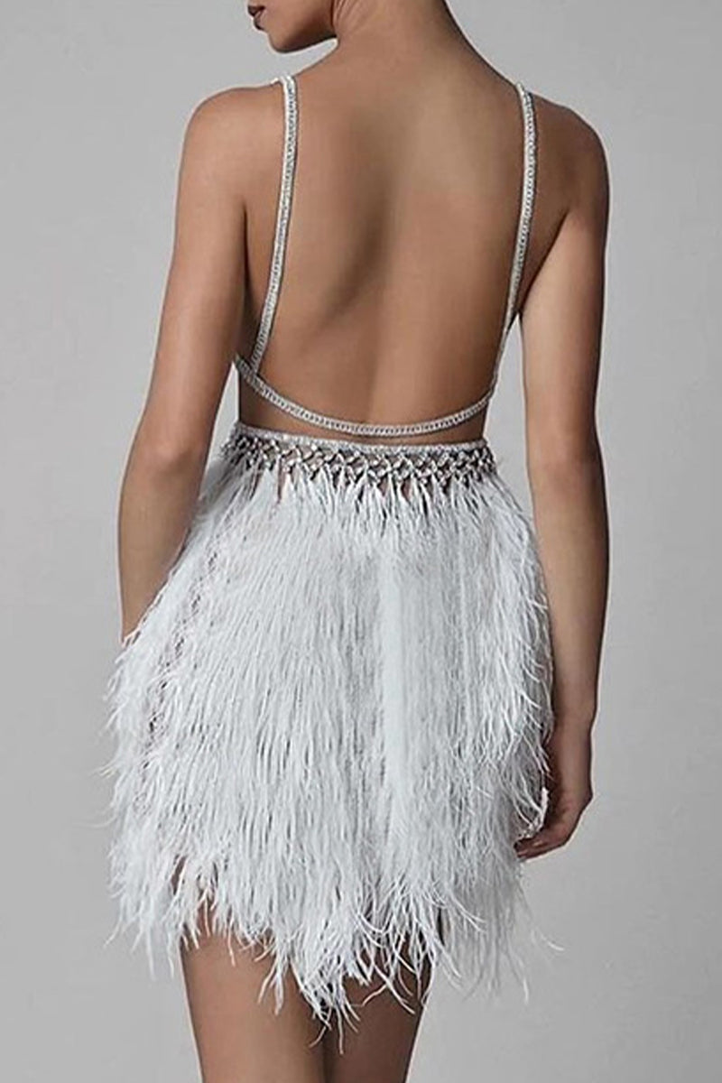 Back view of a woman in a white mini dress with a feather skirt and open back