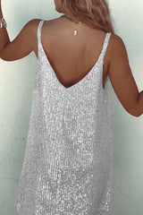 Back view of a woman in a silver sequined mini dress showing her back
