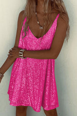 Woman wearing a hot pink sequined mini dress, arms crossed