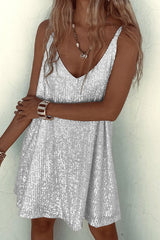 Woman wearing a silver sequined mini dress, arms crossed