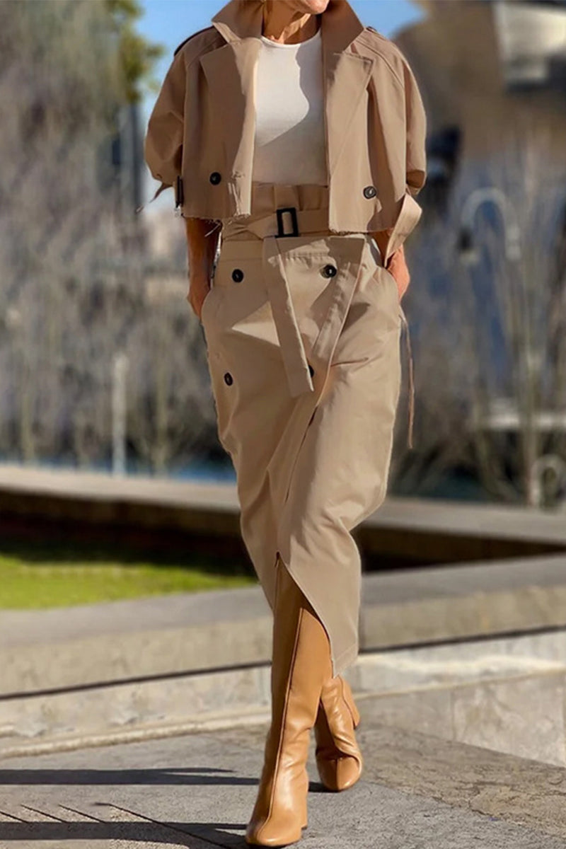 Woman wearing a tan cropped jacket and matching asymmetrical skirt with tan boots