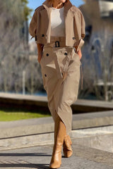 Woman wearing a tan cropped jacket and matching asymmetrical skirt with tan boots