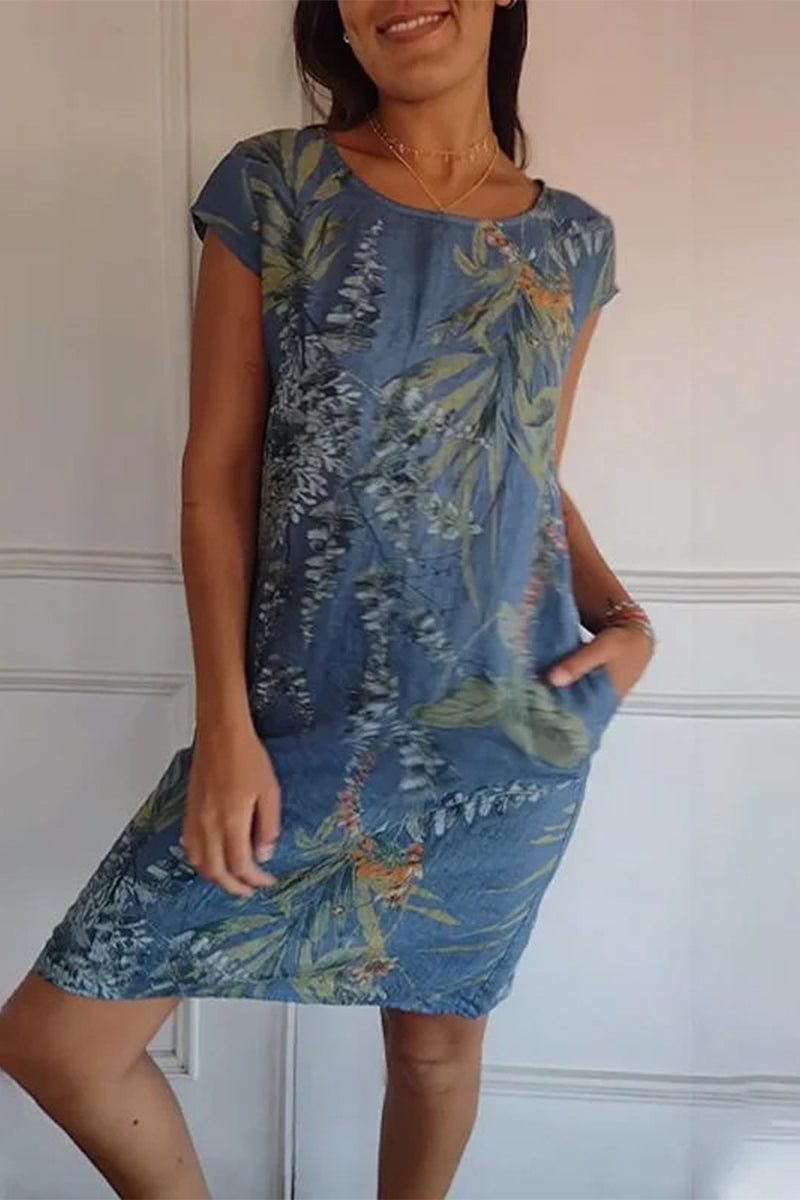 A woman wearing a blue floral print cap sleeve dress with pockets.