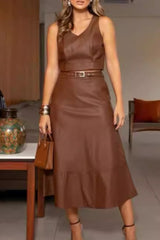 woman wearing a brown leather two-piece set with a cropped top and midi skirt